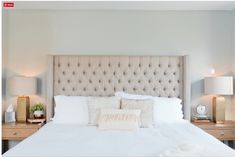 a white bed topped with pillows and two nightstands