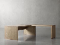 a wooden desk sitting on top of a floor next to a white wall and gray walls