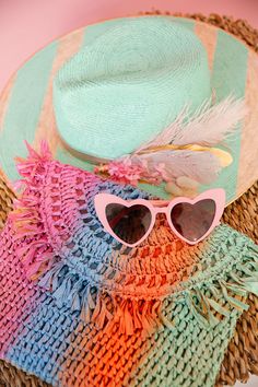 Shade up in style with THE AQUAMARINE SUN HAT! This playful straw hat features cool mint stripes and a sequin sunglasses patch. The white and pink feather and flower combo with sparkling rhinestones adds a touch of whimsy, while the gold band completes the look. Perfect for any sunny day adventure! This hat is ONE OF A KIND, created by our owner Stephanie. To receive item quicker, expedited shipping is available at checkout. Straw Clutch, Pink Feathers, Functional Accessories, Rainbow Stripes, Sunny Day, Sun Hat, Gold Band, Straw Hat, Sun Hats