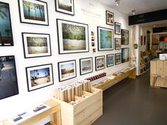 the inside of a store with pictures on the wall and wooden boxes in front of it