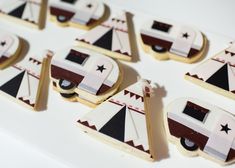 decorated cookies are arranged in the shape of campers and tents on a white surface