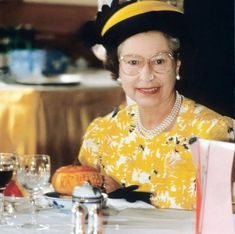 an older woman sitting at a table with wine glasses