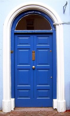 a blue and white building with a cat sitting in front of the entrance to it