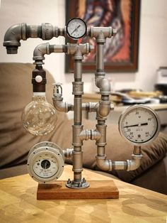 a table topped with pipes and gauges on top of a wooden table next to a couch