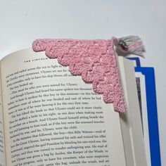 an open book with pink crochet on it