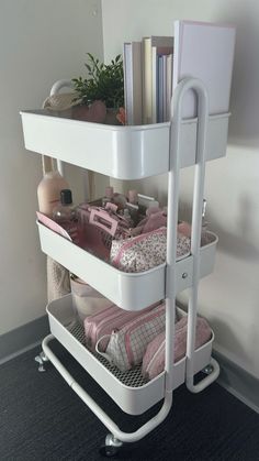 a white shelf with three baskets filled with clothing and other items on top of it