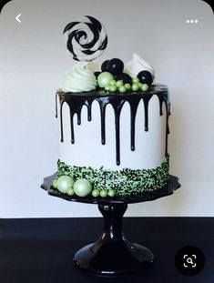 a black and white cake with green decorations