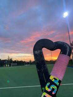 a close up of a tennis racket with the sun setting in the back ground