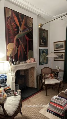 a living room filled with furniture and paintings on the wall above a fire place in front of a fireplace