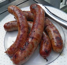 three sausages on a plate with a fork