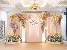 a room with flowers and candles on the floor, decorated in pinks and yellows