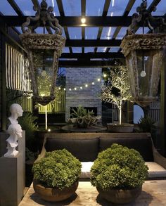 an outdoor living area with potted plants and decorative lights on the windowsills