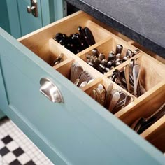 an open drawer in a kitchen filled with utensils