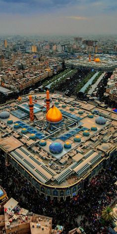 an aerial view of a large building in the middle of a city with lots of people around it