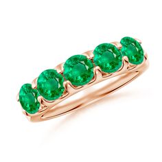 a gold ring with three emerald stones on the sides and four diamonds in the middle