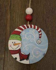 a snowman ornament hanging from a string