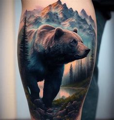 a bear on the leg with mountains and trees in the background, done by tattoo artist mike