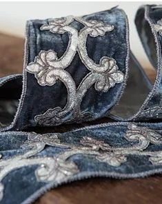 a pair of blue velvet shoes sitting on top of a wooden floor