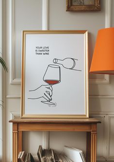 a framed poster with a hand holding a glass of red wine on top of a table