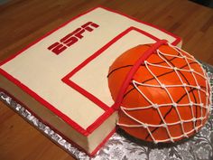 a cake made to look like a basketball ball on top of a book that is wrapped in foil