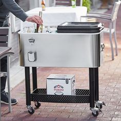 a man standing next to a table with a cooler on it