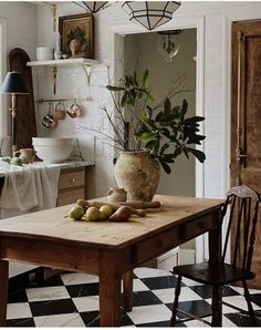 a table with some fruit on it in a kitchen next to a potted plant