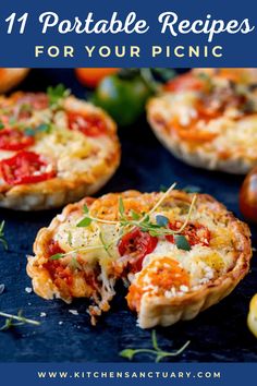 several mini pizzas with different toppings on a blue tablecloth next to tomatoes and lemons