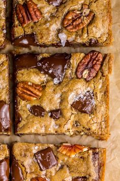 chocolate pecan bars cut into squares and arranged on top of parchment paper with pecans