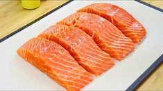 raw salmon on a cutting board ready to be cut into pieces and put in the oven