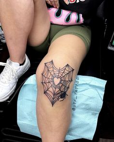 a woman with a spider web tattoo on her leg