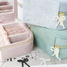 two pink and blue jewelry cases sitting next to each other on top of a table