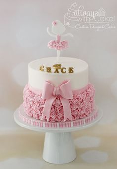 a white cake with pink ruffles and gold lettering