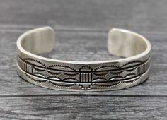 "Beautifully stamped and etched sterling silver bracelet handcrafted by well known Navajo artist Bruce Morgan. Bruce has been smithing since 1983 and is well known for his work in silver and silver with gold overlay. Bracelet is 5.25"" tip to tip inside with a 1"" opening (somewhat adjustable) and should fit a wrist circumference of up to 6.5"". Bracelet weighs 36 grams +-." Southwestern Etched Bangle Jewelry, Western Style Stamped Cuff Bracelet, Southwestern Style Etched Bangle, Adjustable Etched Sterling Silver Southwestern Bracelet, Adjustable Etched Southwestern Sterling Silver Bracelet, Western Sterling Silver Adjustable Bracelet Stamped 925, Southwestern Etched Bracelets For Collectors, Southwestern Sterling Silver Stamped Bangle Bracelet, Adjustable Stamped Southwestern Sterling Silver Bracelet