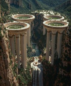 an aerial view of some very tall pillars in the middle of a mountain range with a waterfall running between them