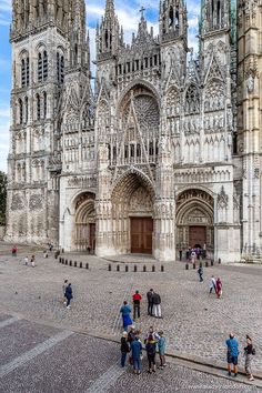 many people are standing in front of an old cathedral