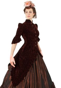 A rich patterned textured velvet makes up the polonaise bodice. The fitted bodice has a high neckline and sleeves with a gentle pouf at the shoulders. The sleeves are caught just above the elbow, and then continue with a ruffle of the same lush velvet fabric. The hemline of the bodice "cuts away" from the center front to form deep points on either side, and a deeply pleated long peplum that has the look of an trained overskirt at the back. The entire hemline has a deep flounce of the same velvet fabric as the bodice. Taffeta covered buttons close the front.  63% Acetate/37% Rayon Velvet  - please dry clean only. The model is also wearing a skirt, hat, earrings, gloves, extra full crinoline, and boots - all are available priced separately. Recollections clothing is made in America. The foll Fitted Victorian Dress With Boned Bodice, Elegant Victorian Dress With Ruffles And Baroque Shape, Elegant Fitted Victorian Dress In Baroque Style, Victorian Fitted Dress With Boned Bodice, Fitted Victorian Dress With Ruffles For Costume Party, Fitted Victorian Dress With Ruffles In Baroque Style, Fitted Victorian Dress With Ruffles, Victorian Dress With Ruffles For Fall, Elegant Victorian Dress With Ruffles For Fall