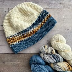 two skeins of yarn sitting next to each other on top of a wooden table