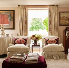 a living room with couches, chairs and a table in front of a window