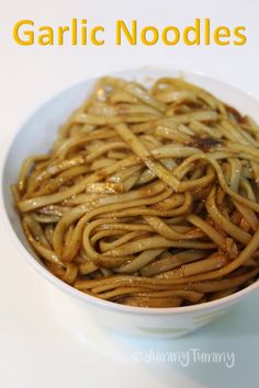 a white bowl filled with noodles on top of a table next to an orange sign that says garlic noodles