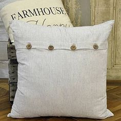 two pillows sitting next to each other on top of a wooden floor in front of an old door