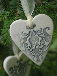 two ceramic heart ornaments hanging from a tree