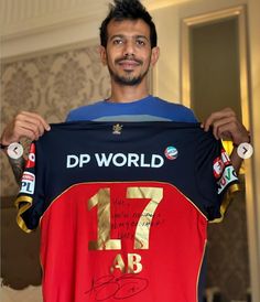 a man holding up a shirt that says dp world with the number seven on it