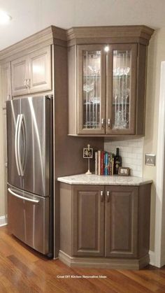 a kitchen with wooden floors, cabinets and a refrigerator freezer combo in the corner