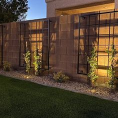 a fence that is next to a building with plants growing on the side of it