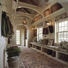 a hallway with brick flooring and lots of windows