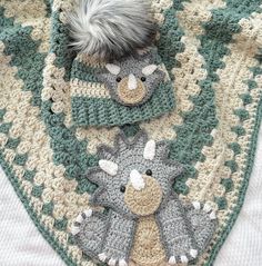 a crocheted blanket with two stuffed animals on it