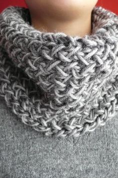 a woman wearing a gray knitted cowl