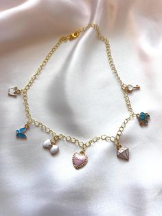 Step into a fairytale with this enchanting Cinderella-inspired charm necklace. This stunning gold chain features a delightful array of charms, including a regal crown, a delicate butterfly, a sparkling rhinestone bow, a heart inscribed with "love," a magical key, a charming carriage, and a dazzling diamond. Each charm tells a part of the Cinderella story, making this necklace a perfect accessory for dreamers and romantics alike. Whether you're dressing up for a special event or adding a touch of magic to your everyday look, this necklace is versatile and timeless. Surprise someone special with a piece that captures the magic and wonder of Cinderella's journey! **Materials - Chain is made of gold plated metal, strong, durable, & corrosion resistant. - Charms are made with high quality alloy Disney Charms, Rhinestone Bow, Jewelry Making Tools, Girly Jewelry, Layered Necklaces, Gift Necklace, Gold Chains, Special Events, Cinderella