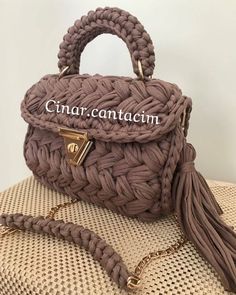 a handbag that is sitting on top of a cushion with a chain attached to it