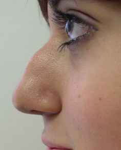 a close up of a woman's face with her nose open